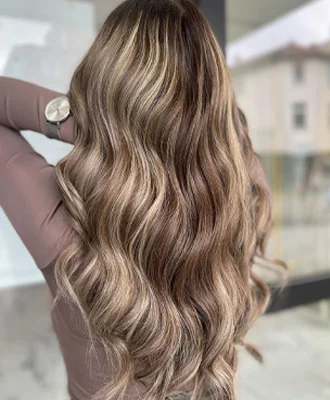 Gewelltes Haar mit weichen blonden Balayage-Reflexen